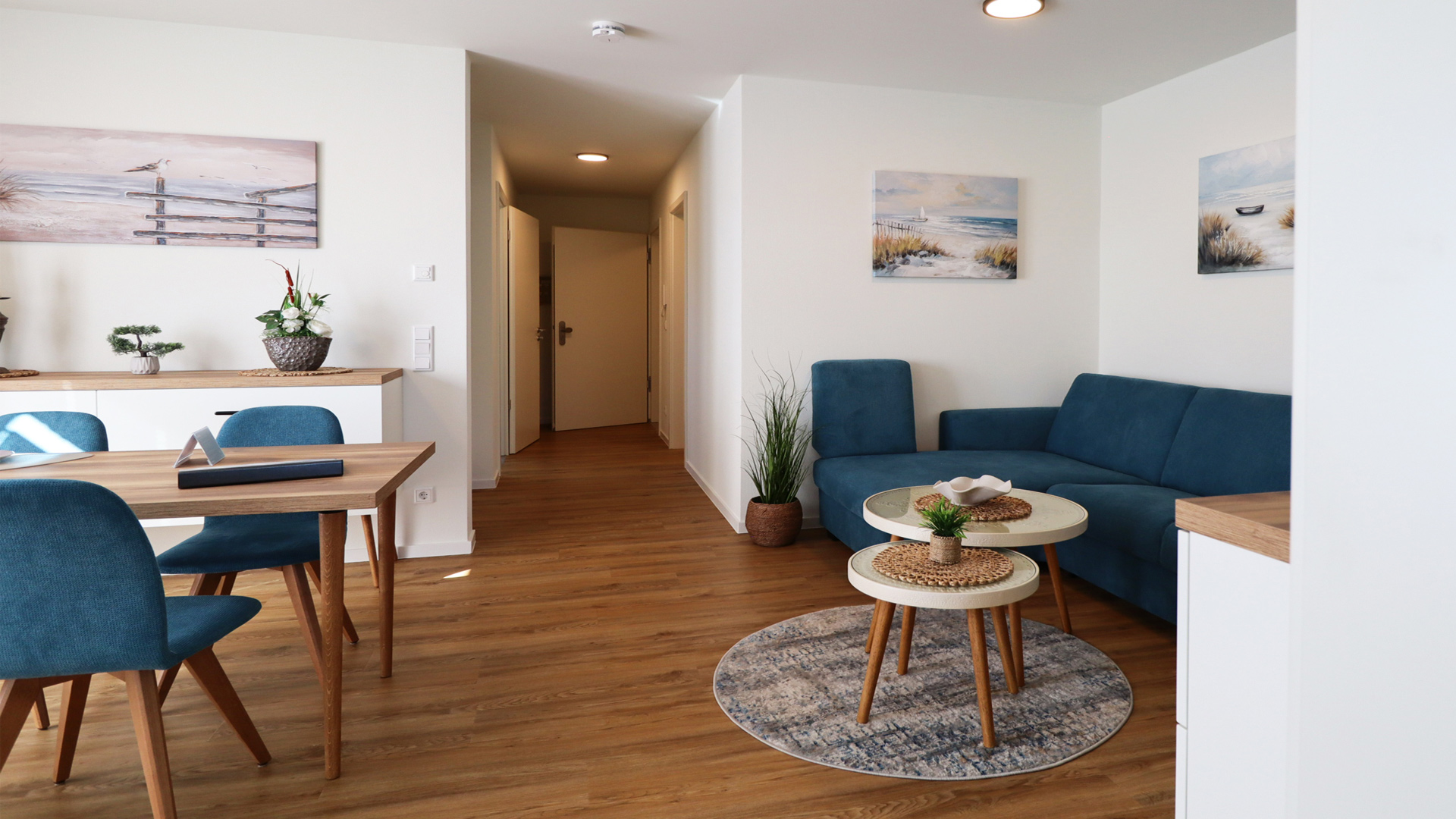 Harmonisch gestalteter Wohn- und Essbereich der Ferienwohnung Tossens mit gemütlicher Sitzecke, stilvollem Esstisch und einladender Atmosphäre.